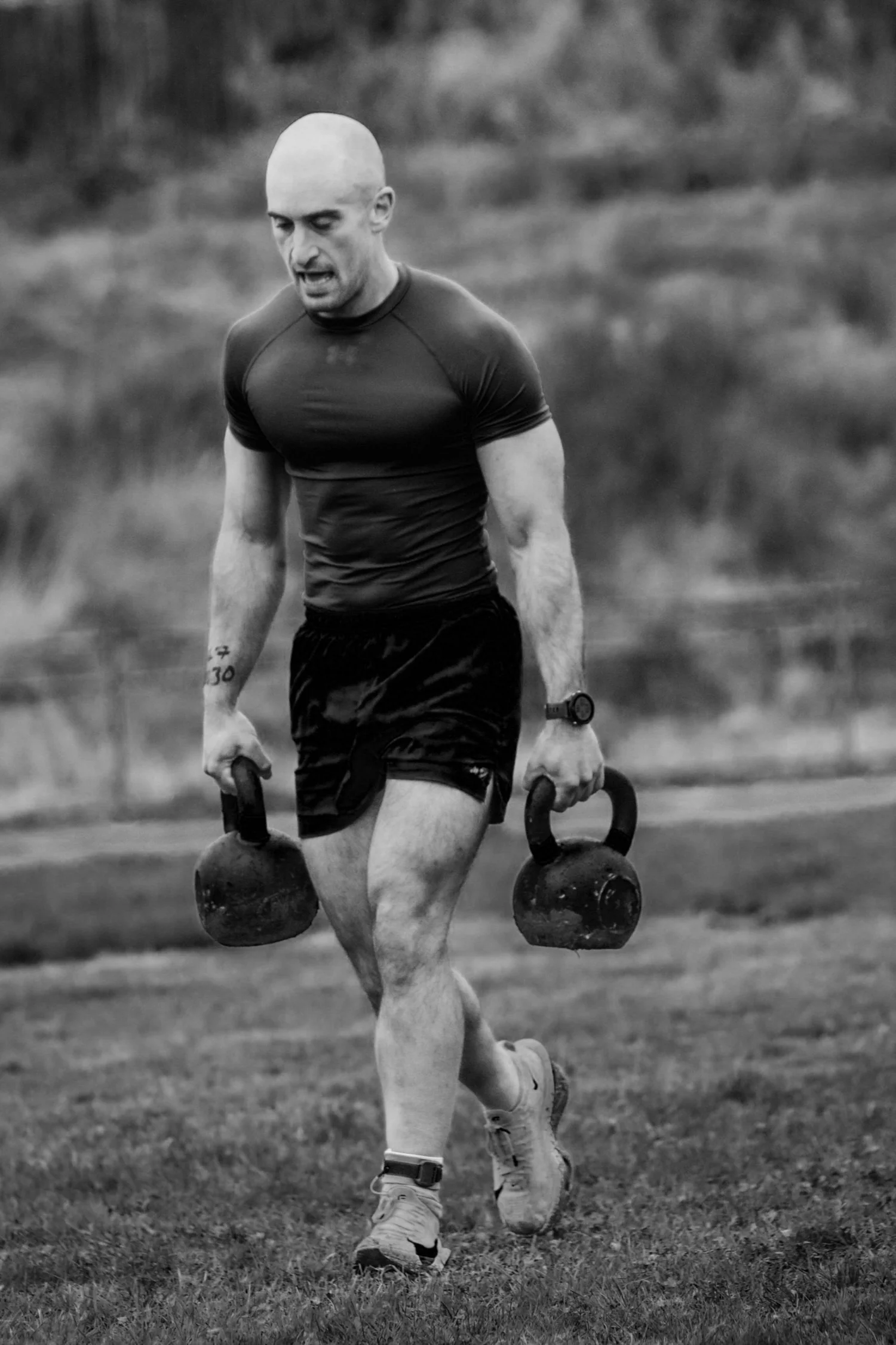 Ein Athlet trägt zwei Kettlebells die 30-Meter-Bahn entlang beim „Farmers Carry Labour“